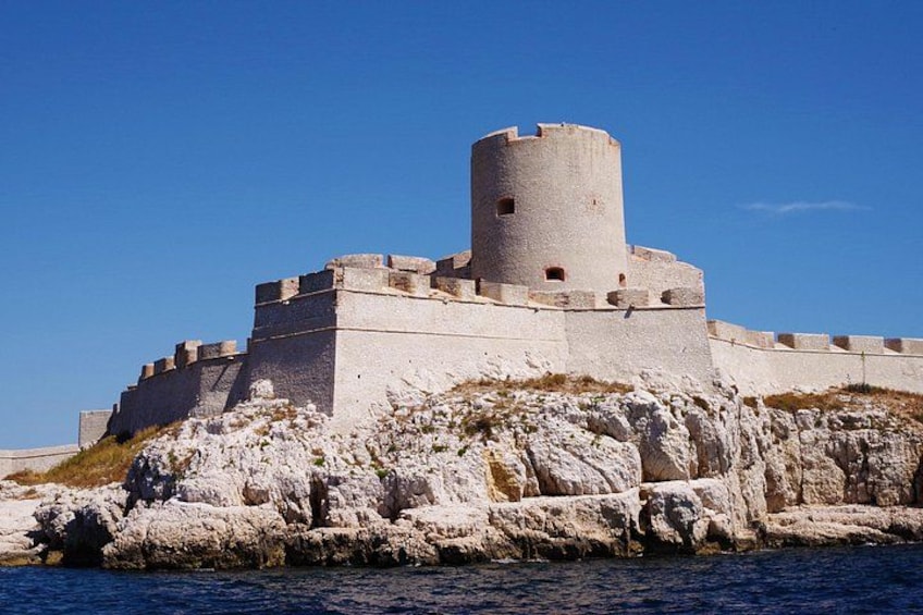 Una fortezza costiera con una torre cilindrica, circondata da un terreno roccioso e dall'acqua. 3