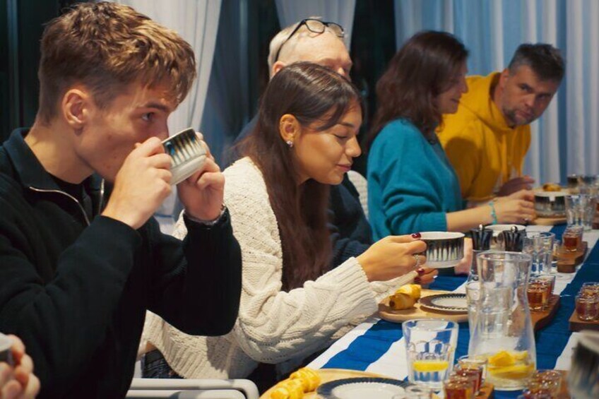 Personas sentadas en una mesa con comida y bebidas. 5