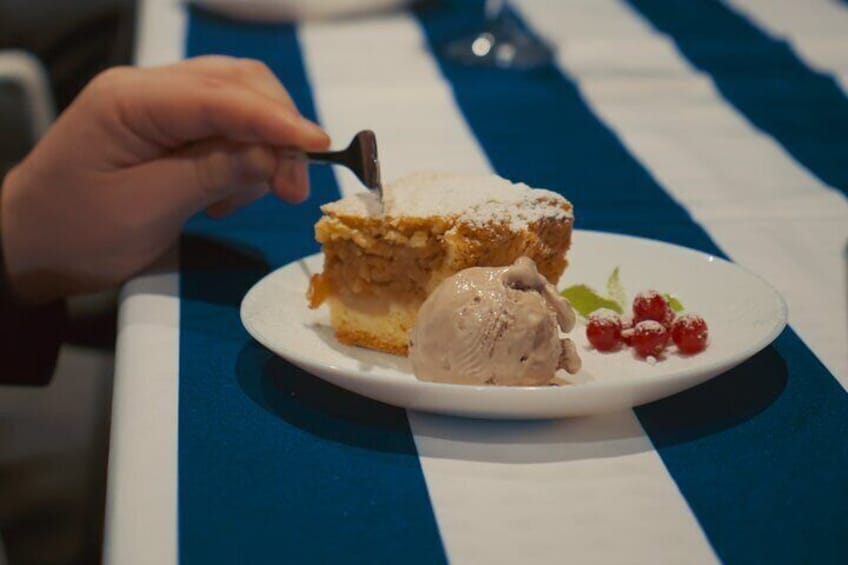 Un plato de postre con una porción de pastel y una bola de helado, decorado con bayas. 2