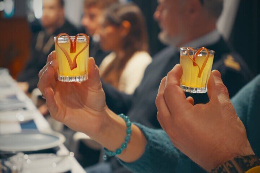Dos personas sosteniendo copas de cóctel con una guarnición con forma de corazón. 1