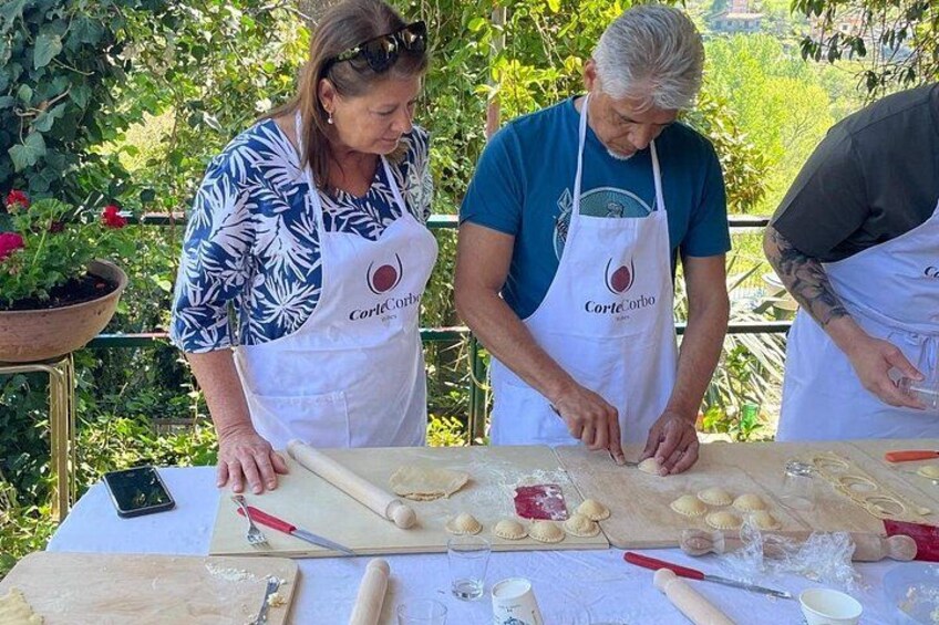 People preparing food outdoors with a table full of ingredients and utensils. 4