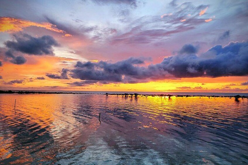 A sunset over a calm body of water with a pier extending into the water. 1