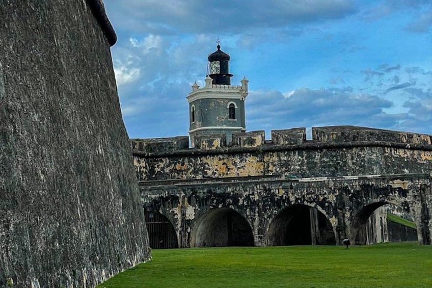 A historic fort with a watchtower, arched gateways, and a large stone wall. 2