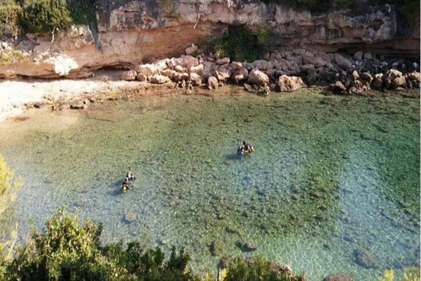 A clear shallow water body with rocks and vegetation. 4