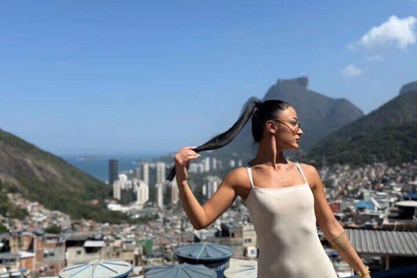 A person on a rooftop with a cityscape and mountains in the background. 3