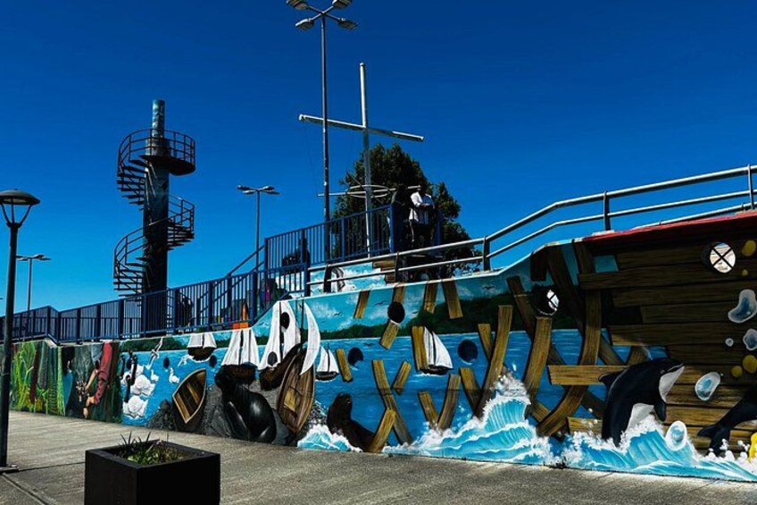 A colorful mural with sea creatures and a lighthouse. 2