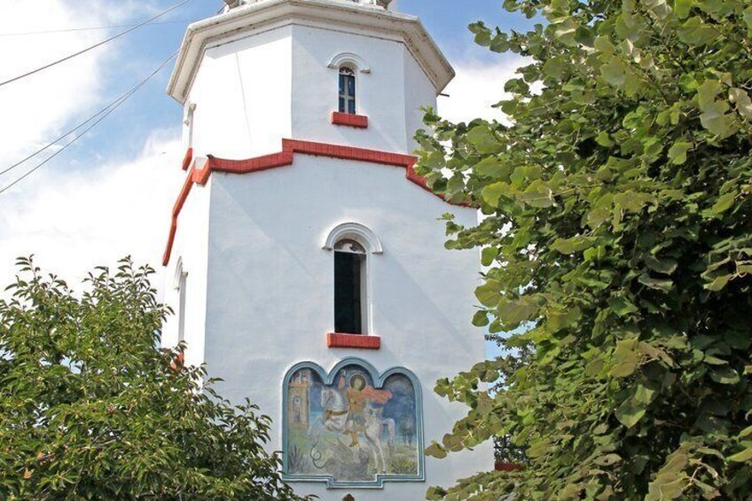 A white church with red trim and a mural. 3