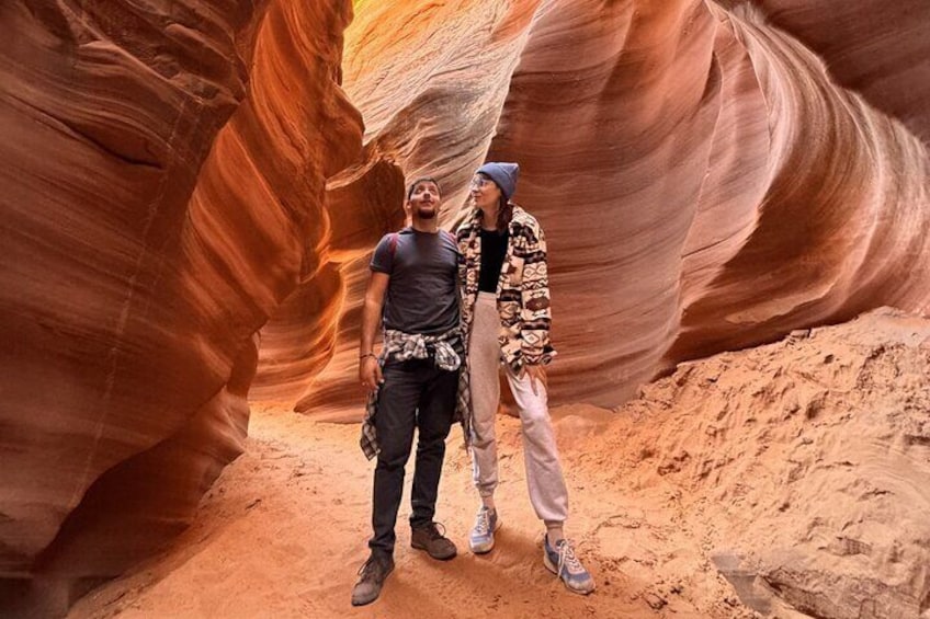 Two people standing in a canyon with red rock walls. 1