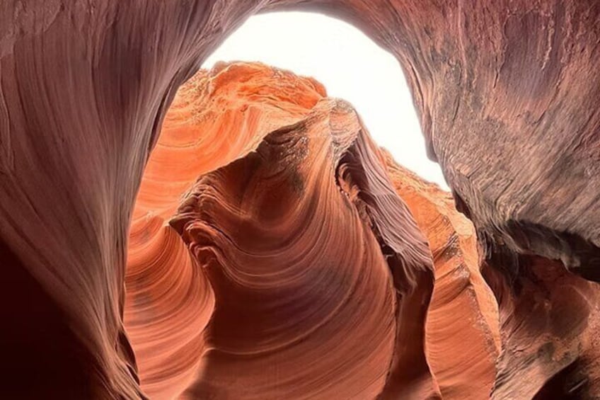 A canyon with layered rock formations and a narrow opening. 4