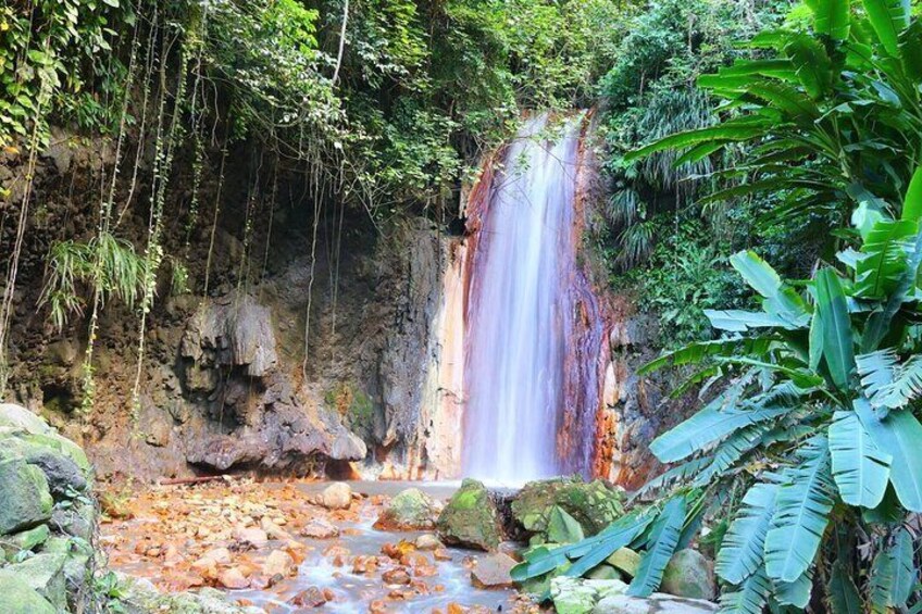 A waterfall surrounded by lush greenery and rocks. 5