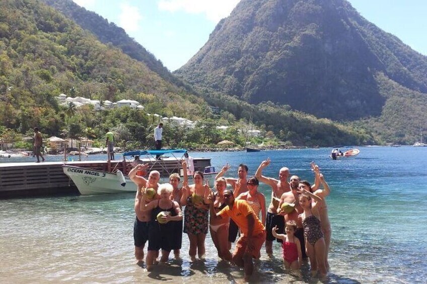 A group of people posing by a dock on a clear day, with a boat named 'OCEAN ANGEL 3' and a mountainous landscape in the background. 2