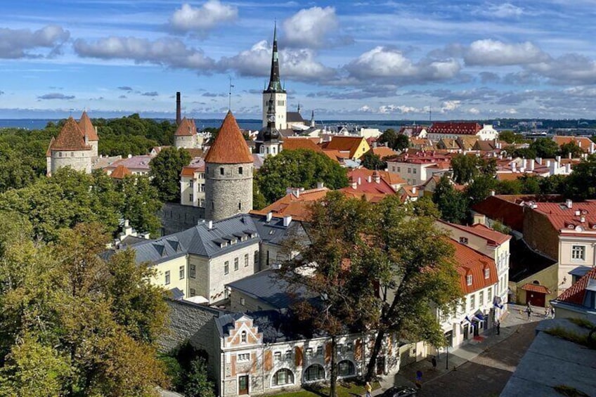 A historic town with prominent towers, a church, and a mix of old and new buildings. 1