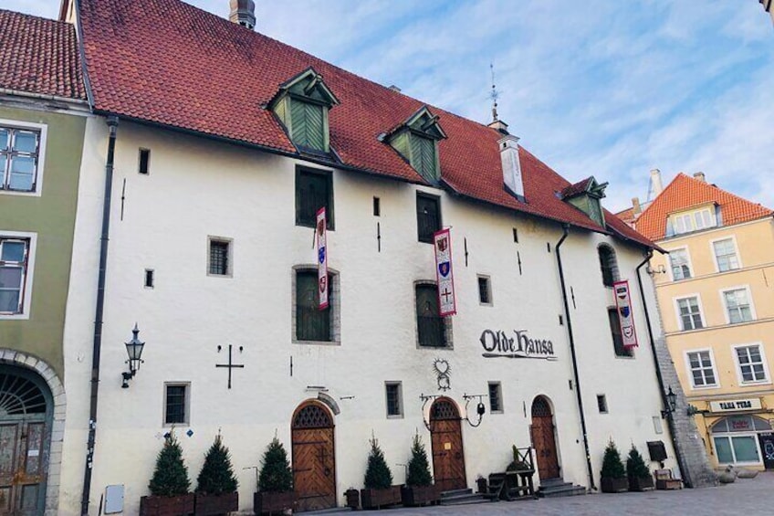 A building with a red roof and white walls, featuring the name 'Ole Danse' and several flags. 2