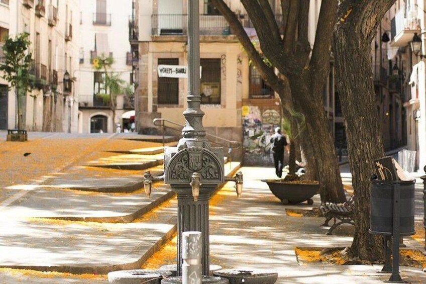 A street with a vintage street lamp, a tree, and a building with a sign. 2