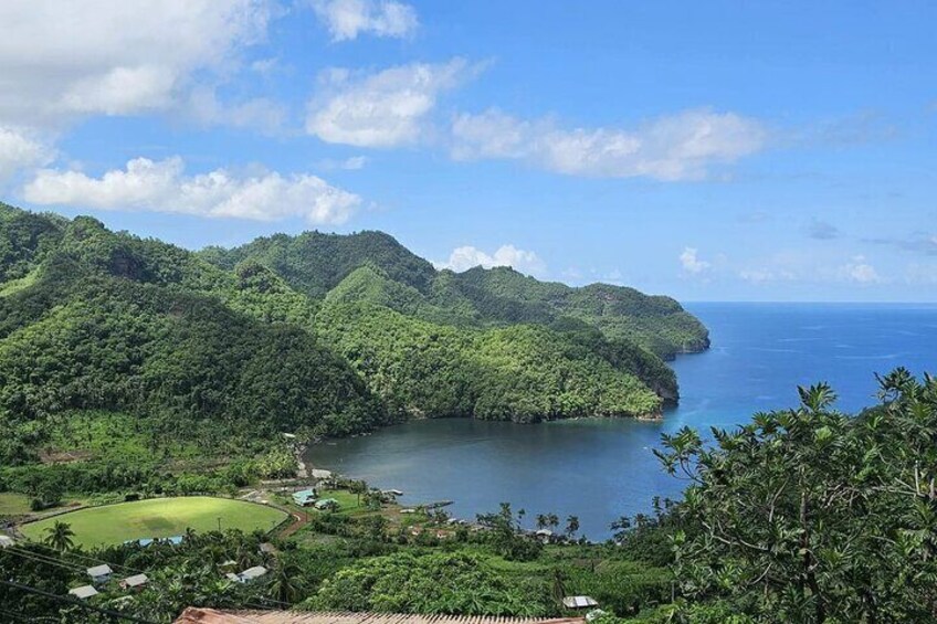 A coastal landscape with lush green hills and a calm sea. 1