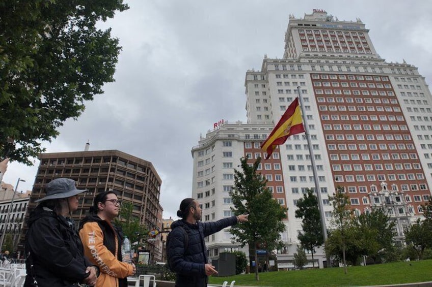 A group of people standing in a park with a flagpole and a flag. 4