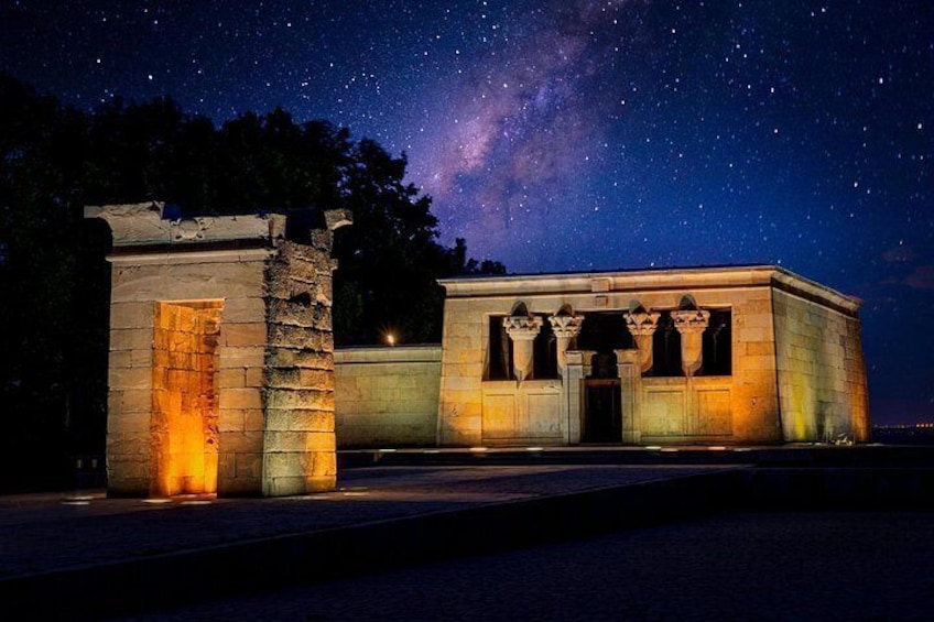 A stone structure with columns under a starry night sky. 1