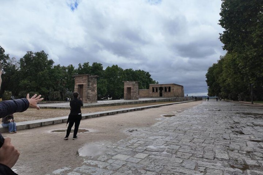 A historical site with ancient stone structures and a paved area. 5