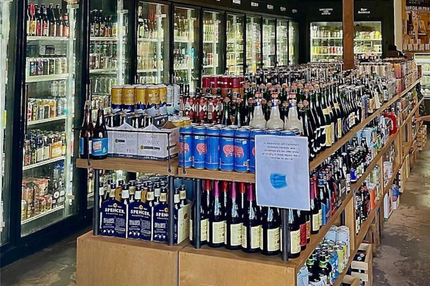 A liquor store with shelves stocked with various bottles and cans. 2