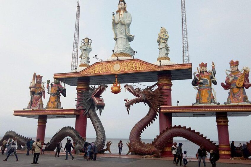 A dragon sculpture, a large white statue, and traditional figures on a platform. 3