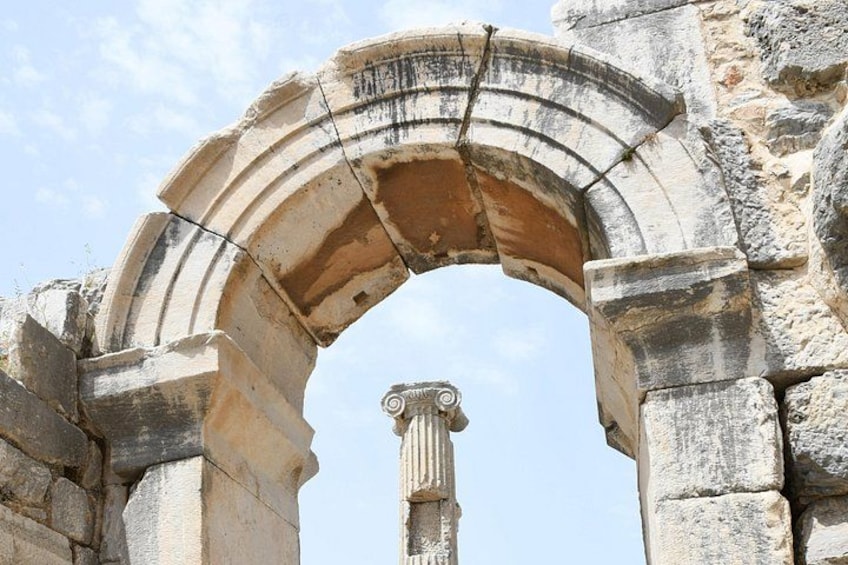 An ancient stone archway with a column at the center. 4