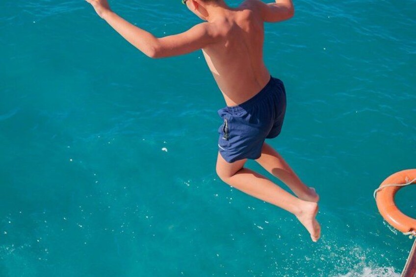 En person hopper i en klar, blå pool. 2