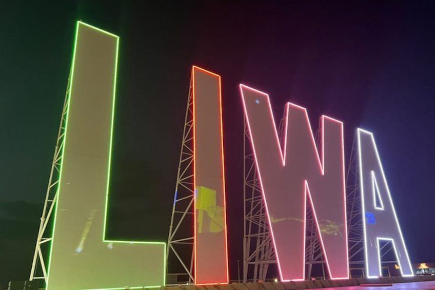 Illuminated letters spelling 'LIWA' with a truss structure. 2