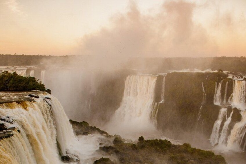 Una cascada grande con múltiples niveles, rodeada de niebla y vegetación. 1
