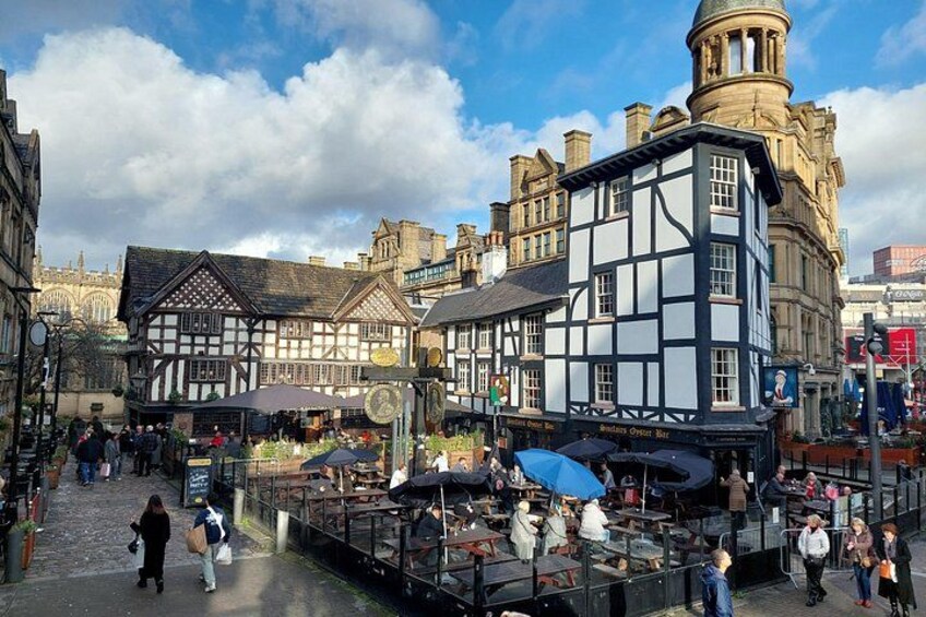 A bustling market square with traditional half-timbered buildings, a prominent clock tower, and a variety of stalls. 2