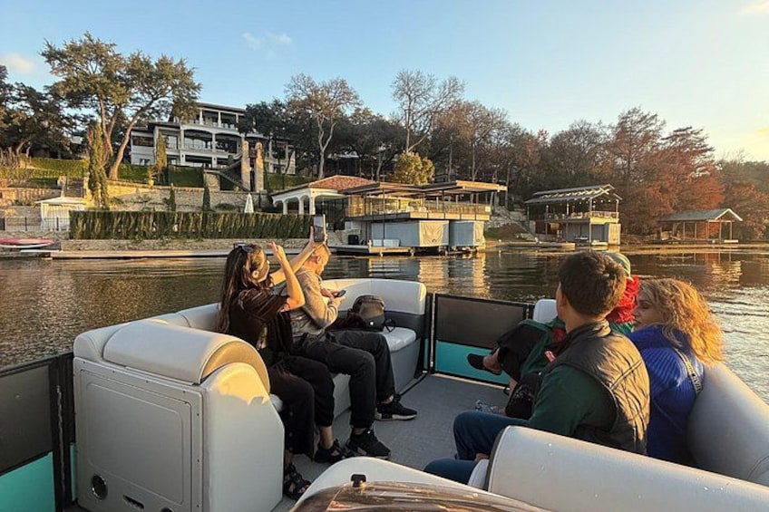 A group of people on a boat near a waterfront with houses in the background. 2