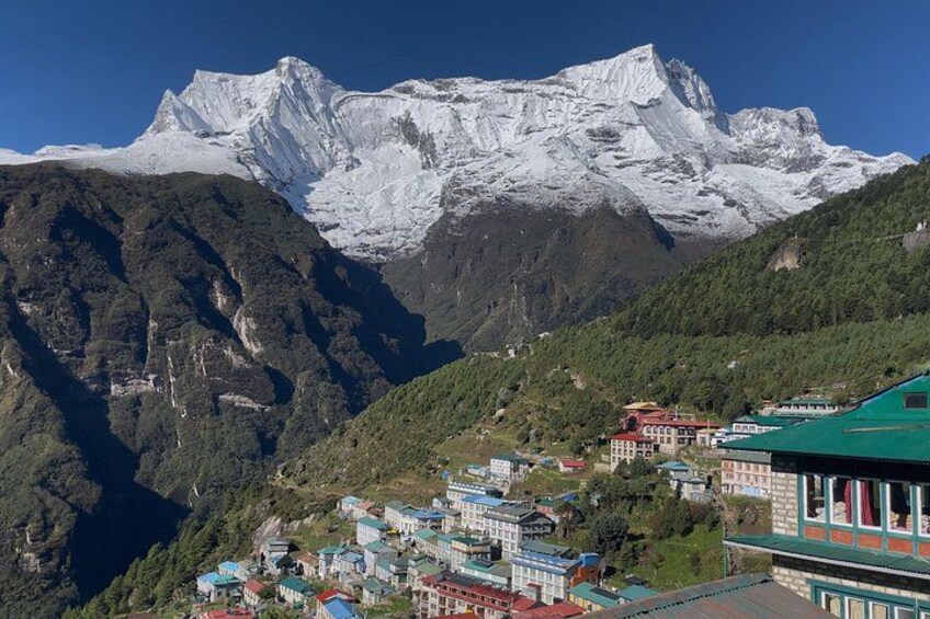 A mountainous landscape with a snow-capped peak, a village with colorful buildings, and a river valley. 4