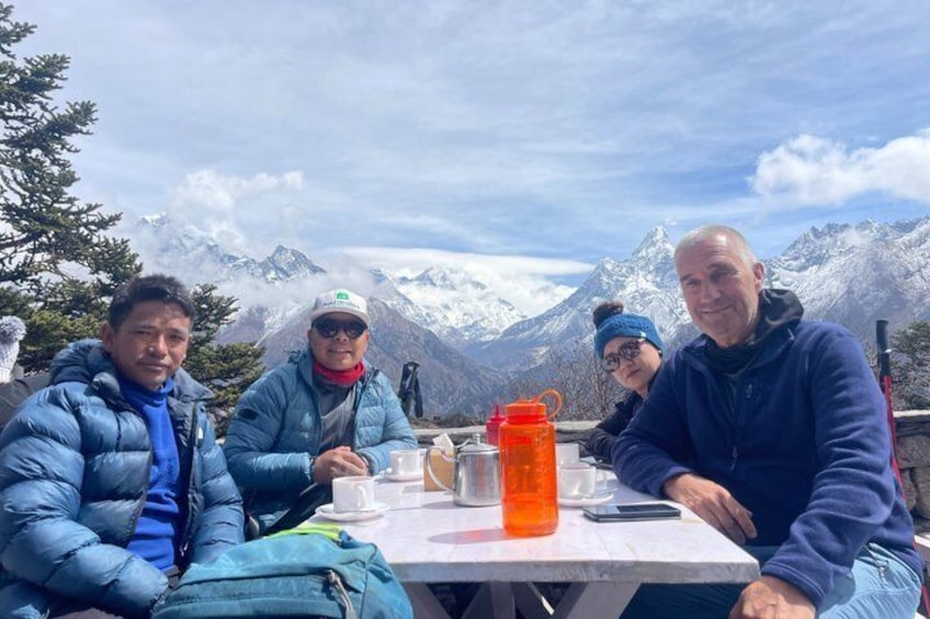 Four people sitting at a table with a mountain backdrop. 3