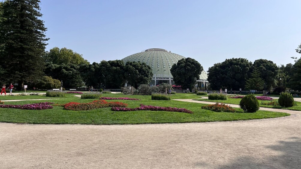 A park with a large dome-shaped building, surrounded by well-maintained gardens and trees. 4
