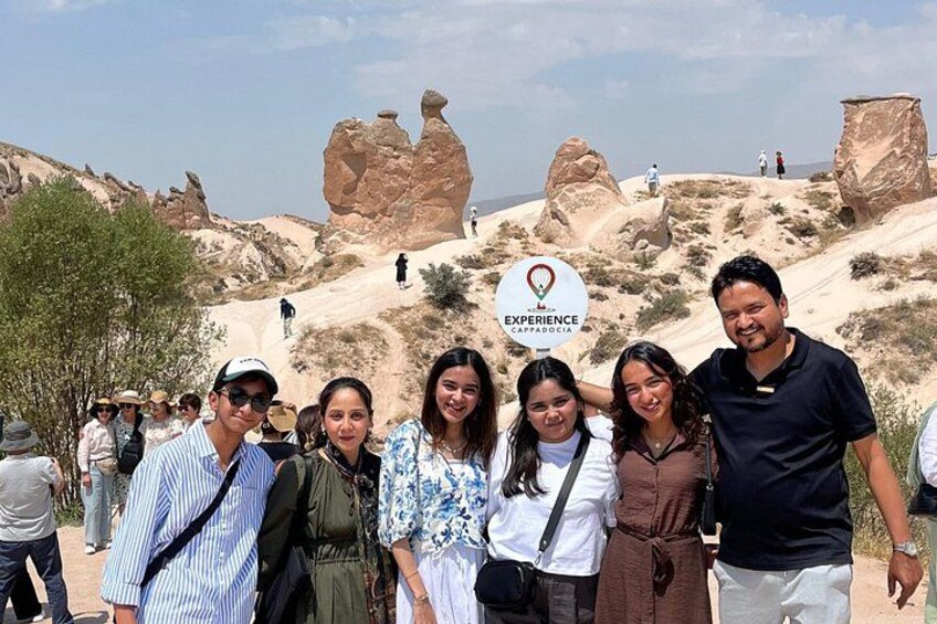 A group of people at a natural landmark with distinctive rock formations. 5