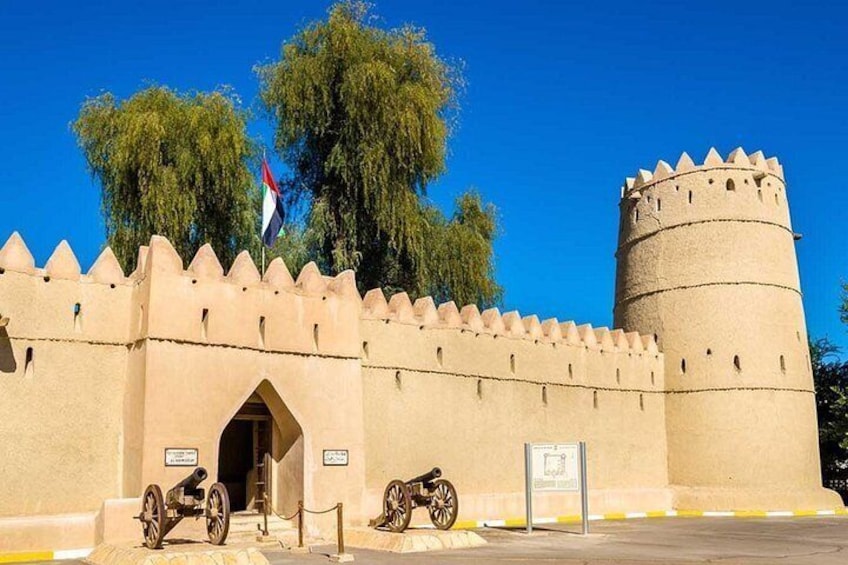 Eine historische Festung mit einem großen runden Turm, einem Tor und einer Flagge. 4