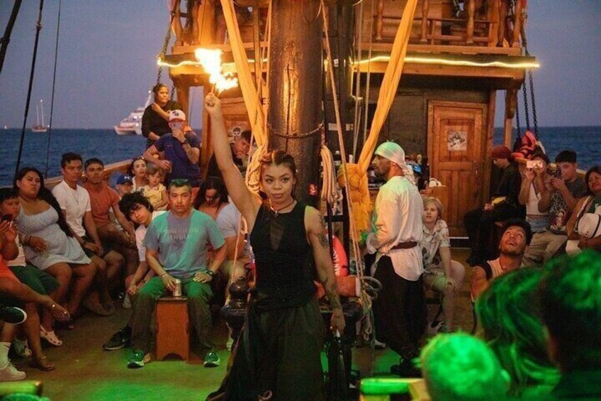 A group of people on a boat with a wooden structure and a person holding a torch. 2