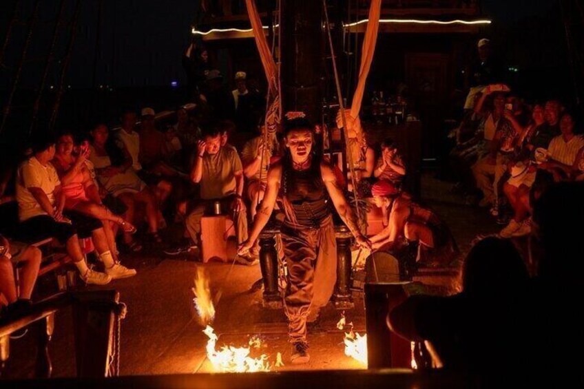 A person performing in a fire-dancing act surrounded by an audience. 5
