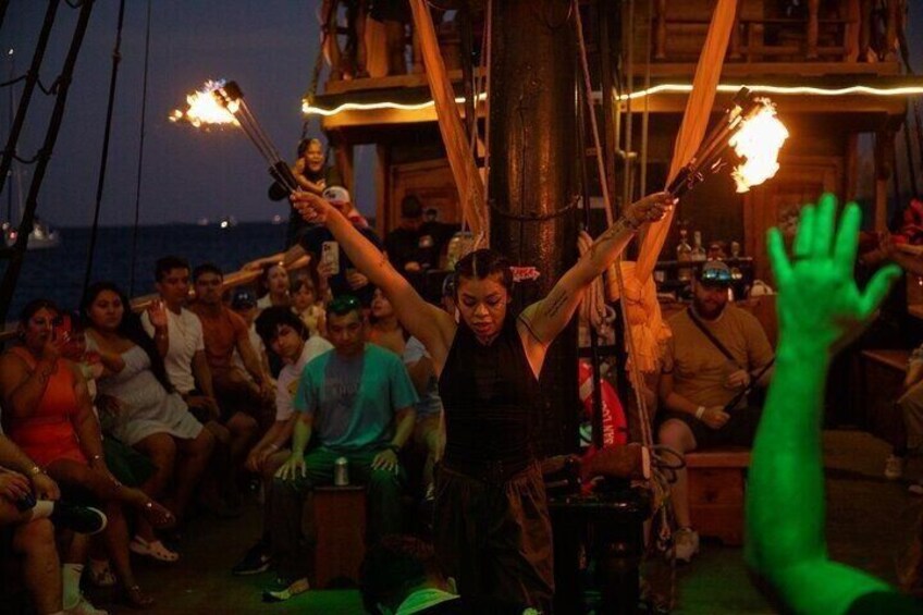 A group of people on a boat at night, holding torches. 3