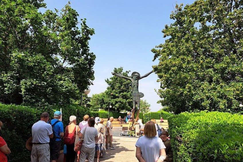 Un grupo de personas reunidas alrededor de una estatua en un parque. 5