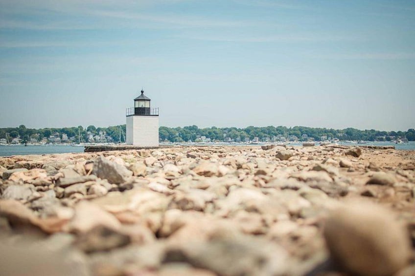A lighthouse on a rocky shore with a clear sky. 3