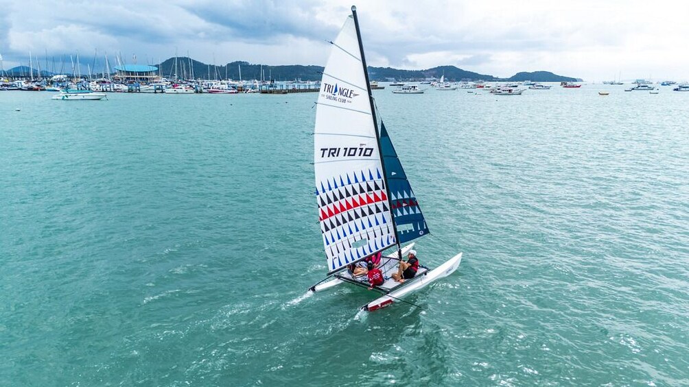 Un velero con vela triangular identificada como TRI 1010 navegando en aguas tranquilas. 2