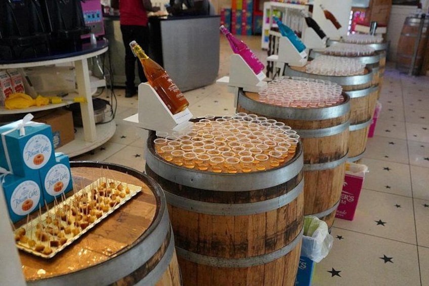 Wooden barrels with a grid of cups, a bottle of champagne, and a tray of food. 2