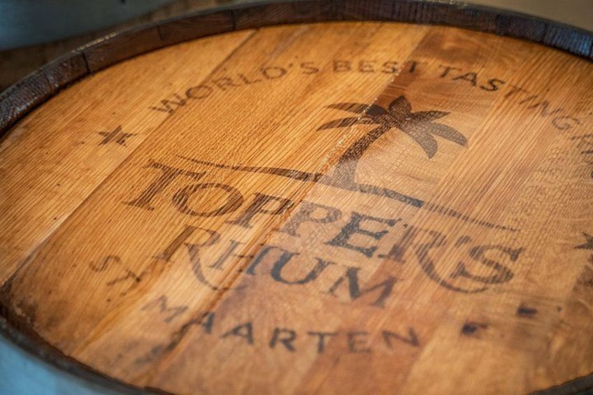 A wooden barrel with text and a palm tree logo. 3