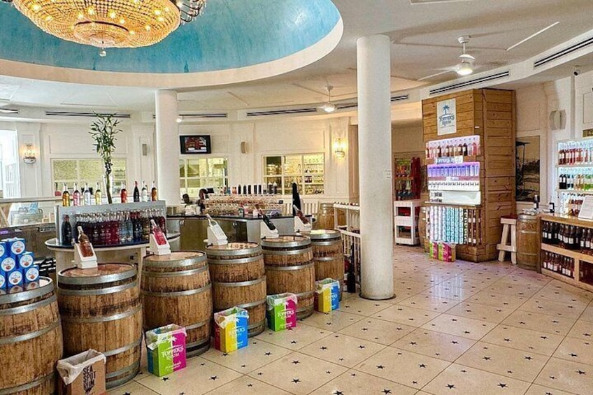 A bar area with wooden barrels, a counter with bottles, and a ceiling with a chandelier. 5
