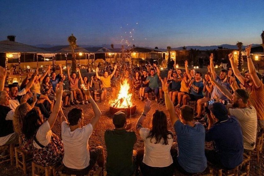 A group of people gathered around a campfire at dusk. 3