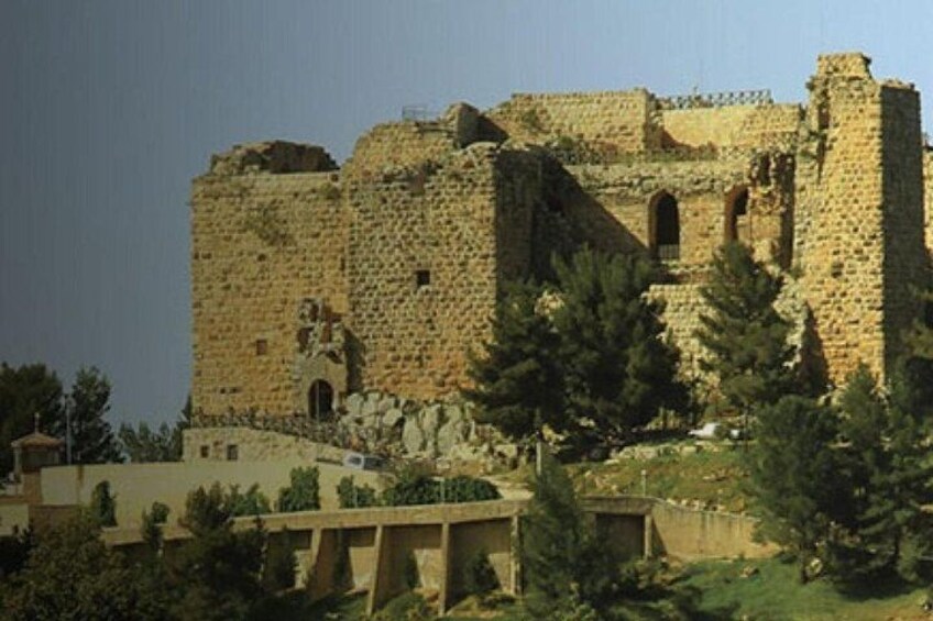 Eine historische Steinburg mit Ruinen, umgeben von Bäumen und einer Brücke. 4