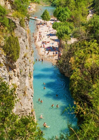 A river with people swimming and sunbathing on the banks. 5