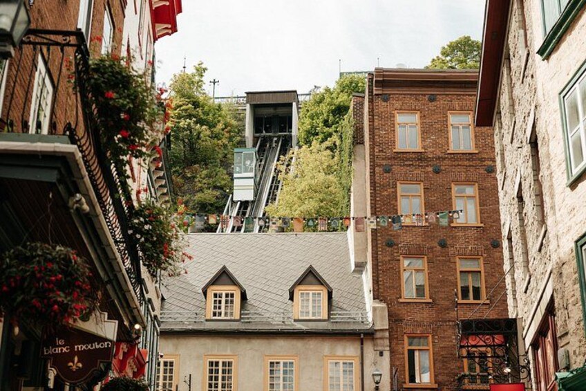 Una calle estrecha con edificios, una escalera y un cartel que dice 'le Blanchot'. 2