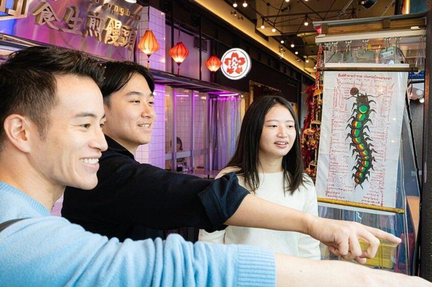 A group of people taking a selfie in a restaurant with a menu board in the background. 5