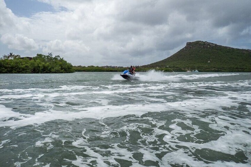 Un jet ski sur une rivière aux eaux agitées, une colline en arrière-plan et un ciel nuageux. 4